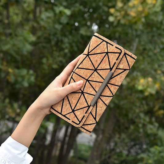 Eco-friendly Cork Grain Multifunctional Fashion Waterproof 3 Fold Hand Wallet held outdoors amongst greenery.